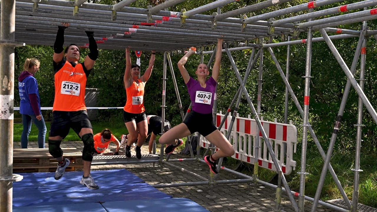 Frauen und Männer hangeln sich durch einen Parcours beim SpardaXtrem Uhingen.