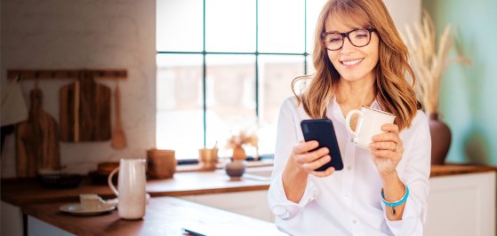 Frau mit Handy und lächelt